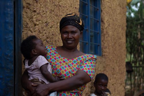 woman smiling carrying a baby