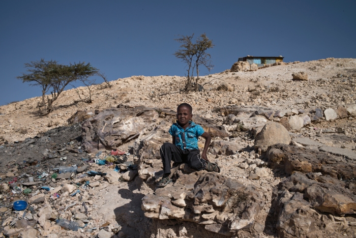 somaliland kid sitting rocky landscape
